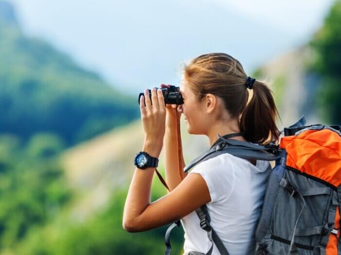 a person on vacation with their binoculars looking out at the scenery.