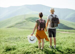 a couple traveling. they are on a mountain holding hands.