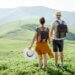 a couple traveling. they are on a mountain holding hands.