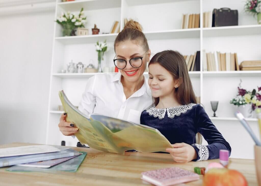 a mom with her daughter reading her a book
