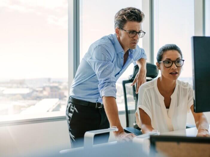 professionals discussing at a woman's computer
