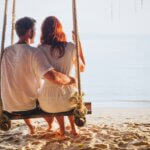 a couple on a swing and a picture of them from behind on a beach on vacation.