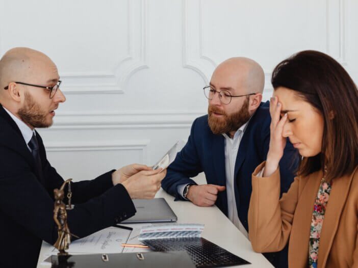 a couple planning with their lawyer and the wife looks like she is emotional