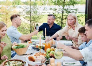 a family sitting around the table eating and talking