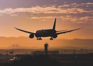 a plane landing from takeoff into the sunset