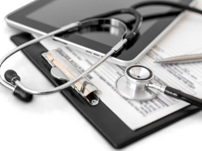 a healthcare clipboard with a patients files and a stethoscope on top