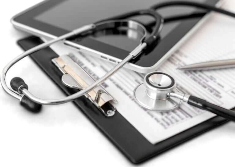 a healthcare clipboard with a patients files and a stethoscope on top