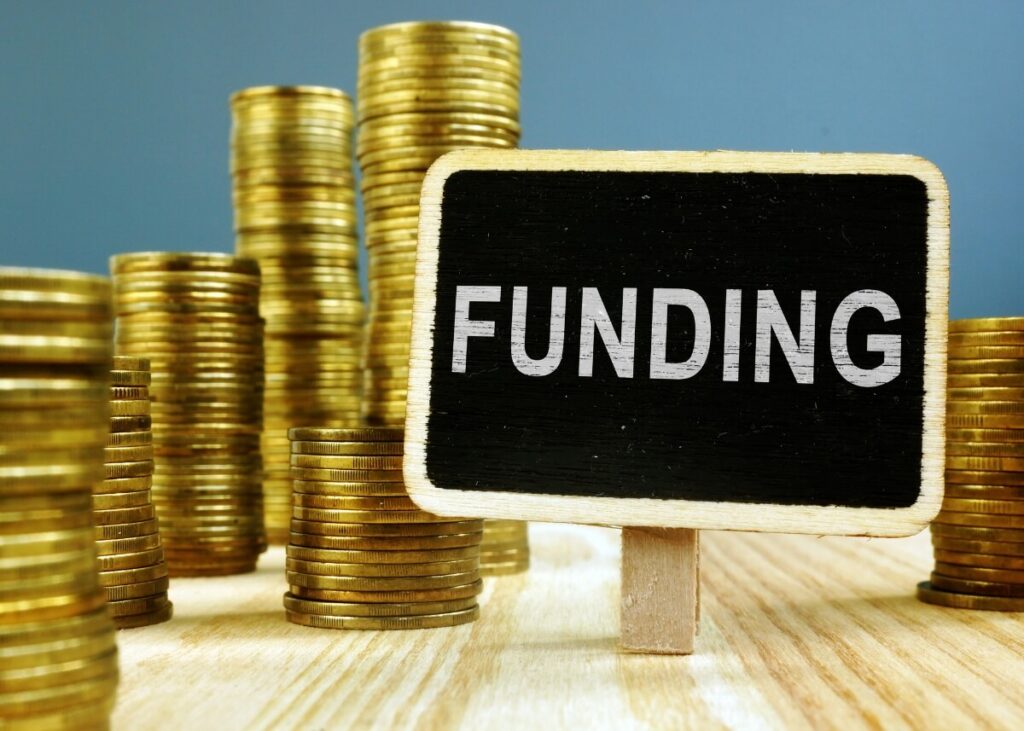 a picture of coins and a sign that says funding