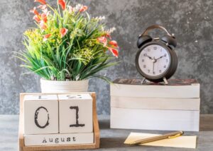 a calendar of august 1st with a plant and a clock