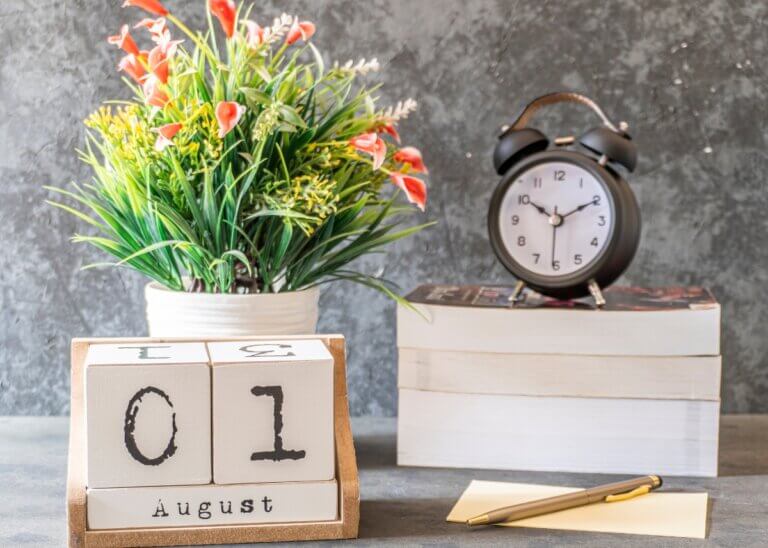 a calendar of august 1st with a plant and a clock