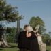 a couple in the cemetery mourning the loss of their loved one.