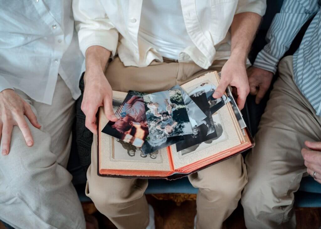 a picture of grandparents looking at old photos and their family heirlooms