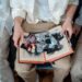 a picture of grandparents looking at old photos and their family heirlooms