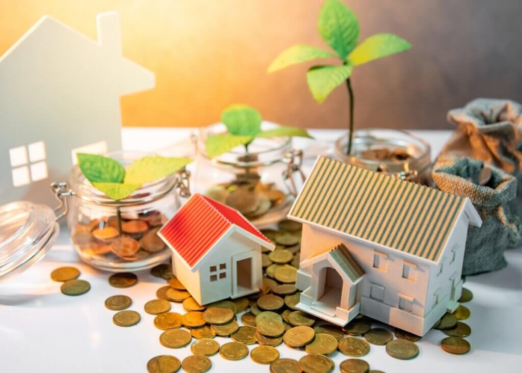 a little house figure with coins and plants surrounding it