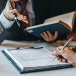 a client in their advisors office going over trust litigation and signing a document
