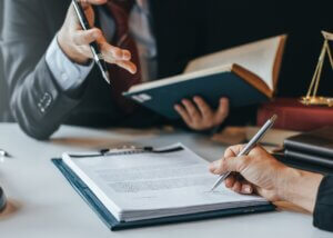 a client in their advisors office going over trust litigation and signing a document