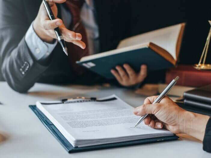 a client in their advisors office going over trust litigation and signing a document