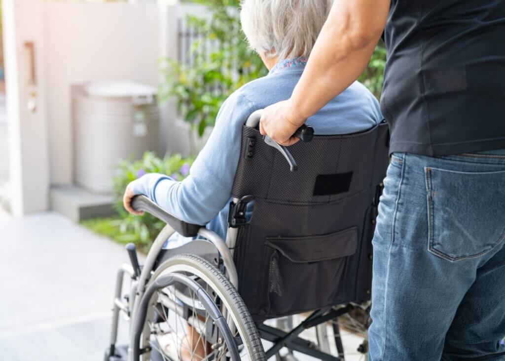 a caregiver wheeling her patient