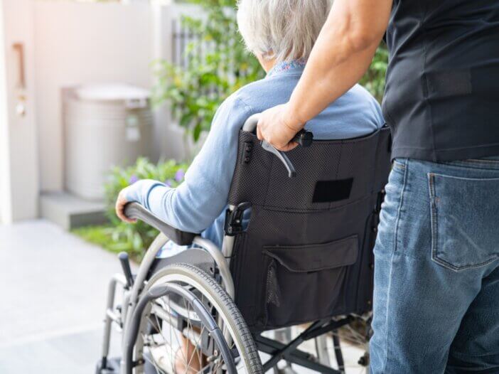 a caregiver wheeling her patient