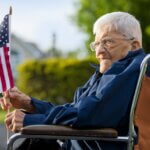 a veteran on a wheelchair holding an american flag