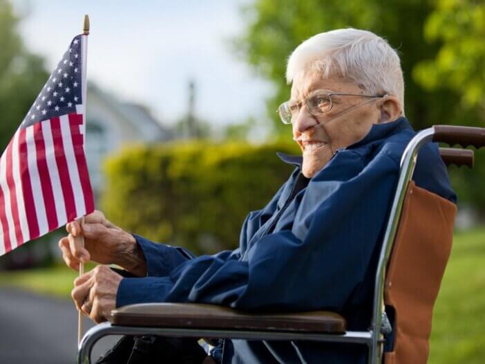 a veteran on a wheelchair holding an american flag