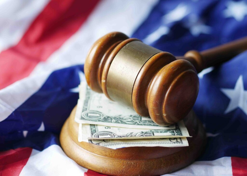 the american flag in the background and some dollar bills on a gavel