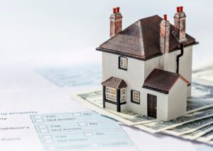 a picture of a small home with tax documents under it