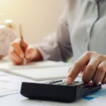 a person on a calculator who is doing their tax deductions