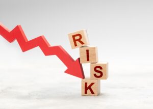 a tower titled risk and an arrow going down