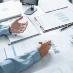 an advisor going over business documents with their client and doing their business well check