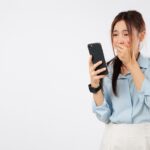 a woman looking at her phone looking shocked at sticker shock