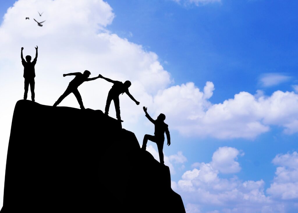 a person climbing up a mountain and someone helping him and then they finally trust themselves to make it up