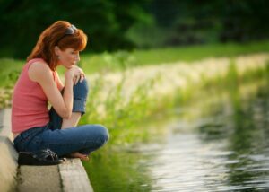 a person pondering at a pond