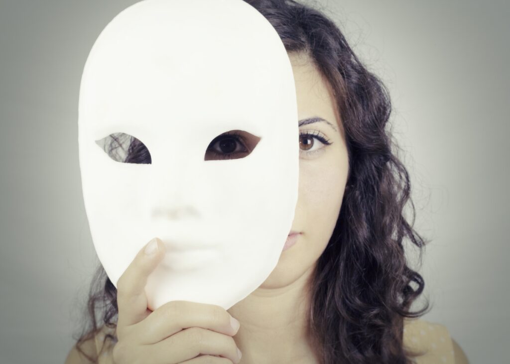 a woman taking off a mask