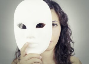 a woman taking off a mask