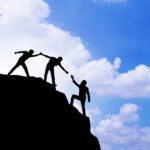 a person climbing up a mountain and someone helping him and then they finally trust themselves to make it up