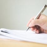 a person writing on their document and fixing the changes being made