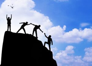 a person climbing up a mountain and someone helping him and then they finally trust themselves to make it up