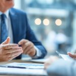 a person planning with an attorney for his business. you can see both of their hands and them reviewing documents