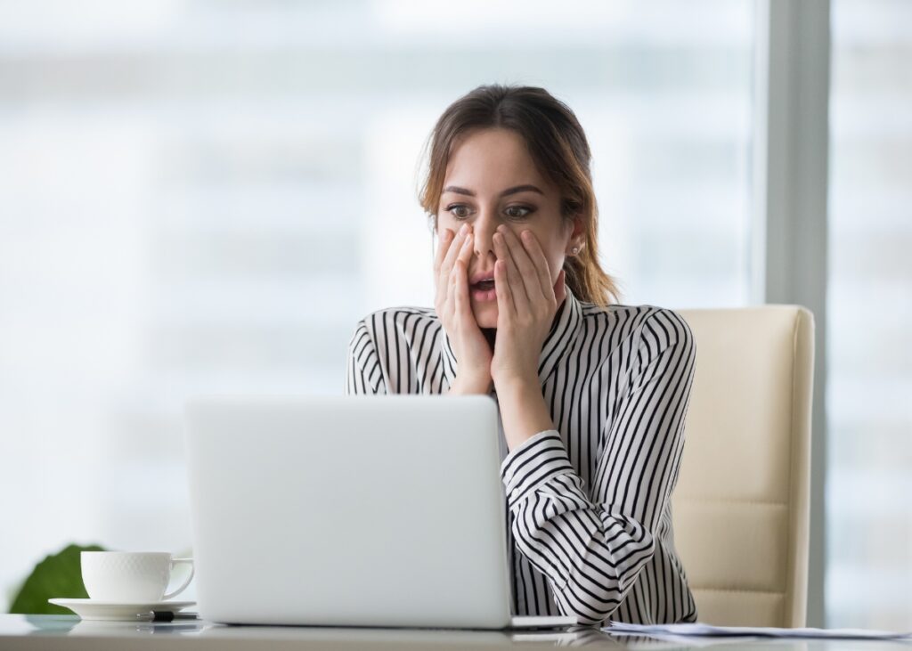 a person acting shocked at her computer