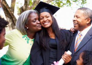 a young adult hugging their parents at graduation