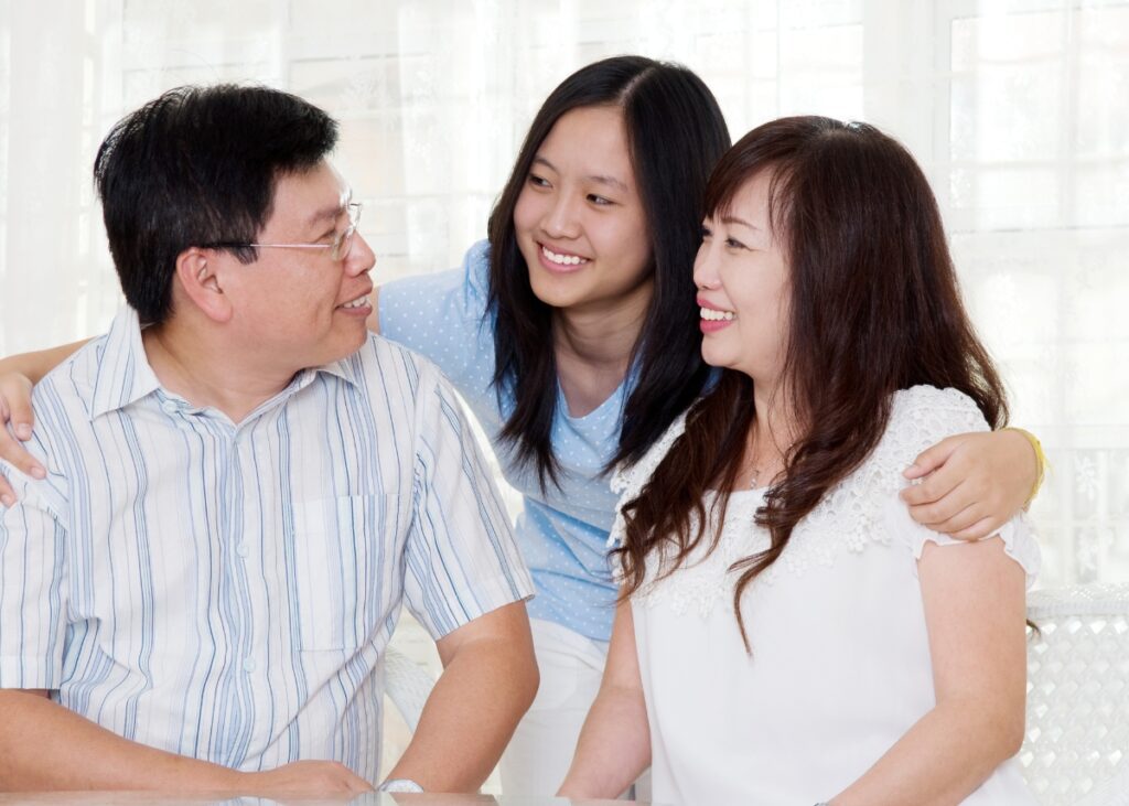 a child with their two parents smiling and looking at each other