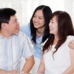a child with their two parents smiling and looking at each other