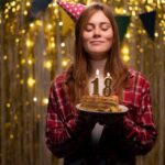 a young adult blowing out her birthday candles that say 18