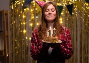 a young adult blowing out her birthday candles that say 18