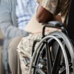 a veteran in their wheelchair talking to an advisor