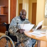 a veteran in a wheelchair looking at papers going over his benefits