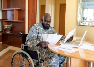 a veteran in a wheelchair looking at papers going over his benefits