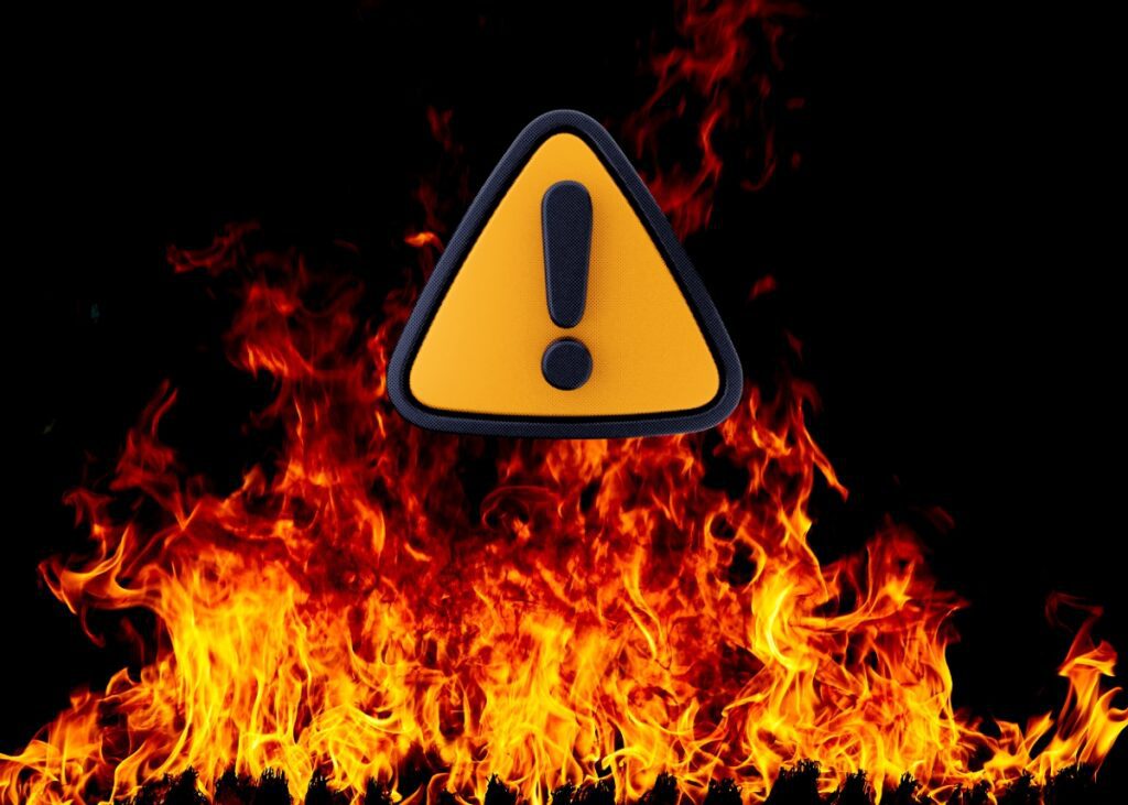 Red flag caution sign with fire